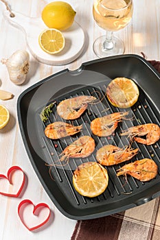 Grilled shrimps on a grill frying pan with wine