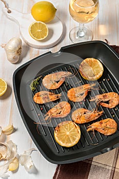 Grilled shrimps on a grill frying pan with wine