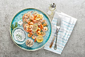 Grilled shrimps or prawns served with lemon, garlic and sauce photo