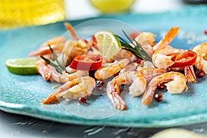 Grilled shrimps or prawns served with lime, rosemary, chili. Seafood. Food recipe background. Close up