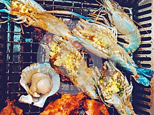 Grilled shrimps seafood and  scallops shell in BBQ stove