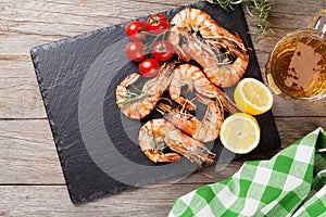 Grilled shrimps on stone plate and beer mug