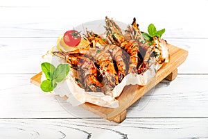 Grilled shrimps on wooden plate.