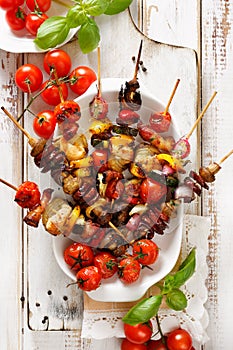 Grilled skewers of vegetables and meat in a herb marinade on white plate