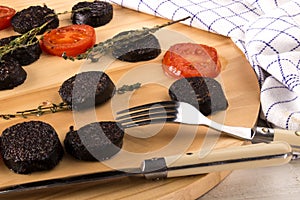 Grilled slice black pudding and tomato with thyme