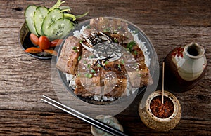 Grilled slice pork with charcoal flame set on rice bowl in Japan