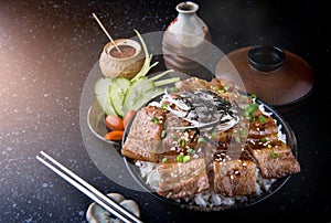 Grilled slice pork with charcoal flame set on rice bowl in Japan