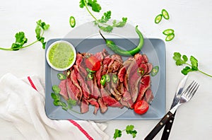Grilled and sliced rare beef skirt steak served with green chimichurri sauce