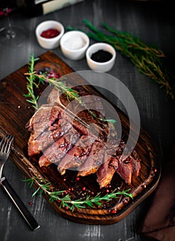 grilled sliced T-bone steak on wooden board