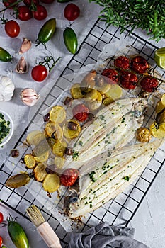 Grilled sole fish with green and red cherry tomatos, potatoe, capers, garlic, parsley and olive oil