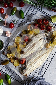 Grilled sole fish with green and red cherry tomatos, potatoe, capers, garlic, parsley and olive oil