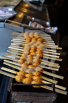 Grilled spicy fish cake or dried Janglon, Chonburi local food, on open metal stove in Nongmon market