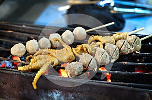 Grilled squid and meatball skewers at a Thailand night market