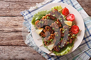 Grilled squid on skewers with vegetables close-up. horizontal to