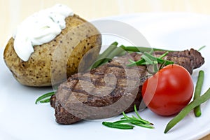 Grilled steak with baked potato and cream