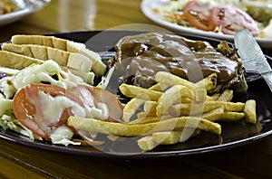 Grilled steak, French fries, Bread and vegetables