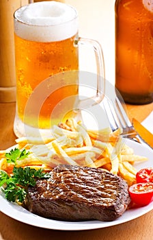 Grilled steak with mug of beer