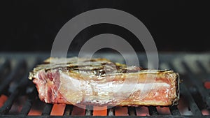 Grilled steak. Ribs on barbecue grill. Cooking delicious juicy meat steaks on the grill on fire. Bbq beef ribs on A