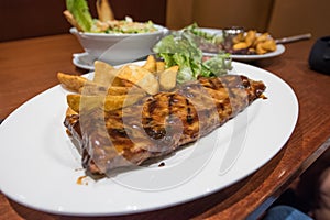 Grilled steaks, French fries and vegetables