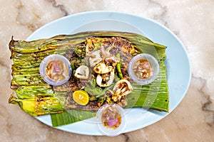 Grilled stingray fish fillet with spices on banana leaf, popular Malaysia delicacy