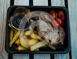 Grilled street food closeup mushrooms, french fries, grilled fish, potato. Served in a plate, selective focus on a