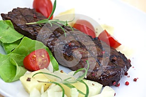 Grilled strip steak with tomato and salad