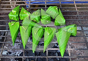 Grilled sweet sticky rice in banana leaf on charcoal stove