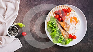 Grilled tacos with egg, fried bacon, vegetables and herbs on a plate top view web banner