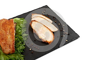 Grilled tasty turkey fillet with salad on slate plate isolated on white background