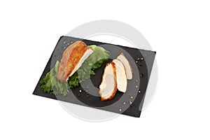 Grilled tasty turkey fillet with salad on slate plate isolated on white background