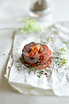 Grilled tomato slices with piper and salt on a white background.