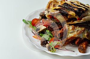 Grilled tortilla wrap with southern style chicken breast with sweet potato fries served on the mix salad