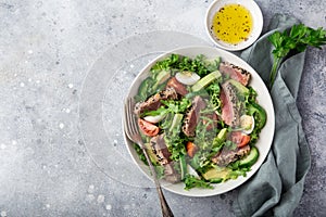 Grilled tuna, avocado, tomato and egg salad in white bowl