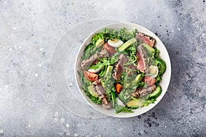 Grilled tuna, avocado, tomato and egg salad in white bowl