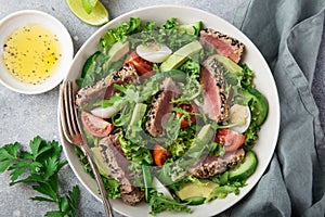 Grilled tuna, avocado, tomato and egg salad in white bowl