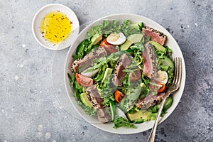 Grilled tuna, avocado, tomato and egg salad in white bowl
