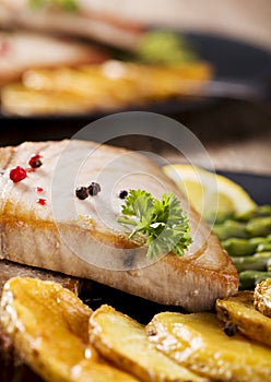 Grilled tuna steak served on asparagus with roasted potatoes