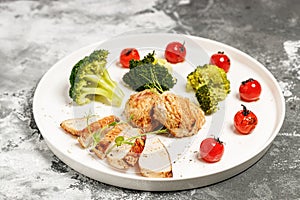 Grilled Turkey breast meat and broccoli on a white plate. Delicious and healthy food. KETO diet concept