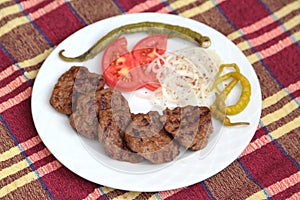 Grilled Turkish meatballs, ( Kofte ), on white plate photo