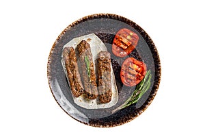 Grilled Urfa shish kebab on a plate with tomato. Isolated, white background. Top view.