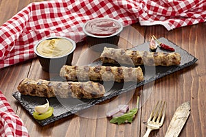 Grilled Veal minced meat with spices on black stone and wooden background