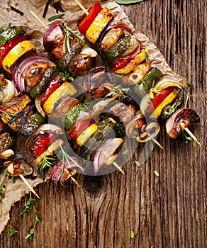 Grilled vegetable and meat skewers on a wooden rustic table