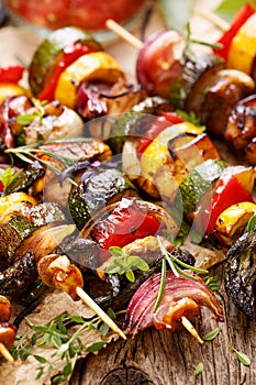 Grilled vegetable and meat skewers on a wooden rustic table