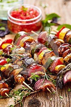 Grilled vegetable and meat skewers on a wooden rustic table