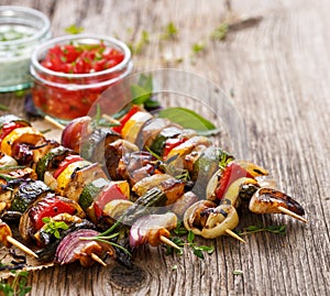 Grilled vegetable and meat skewers on a wooden rustic table