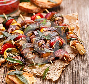 Grilled vegetable and meat skewers on a wooden rustic table