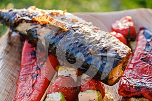 Grilled vegetable skewers and fish of mackerel in a herb marinade on a plate, onion, pepper zucchini tomato roasted barbecue