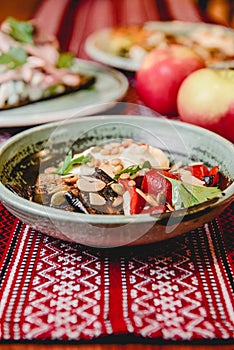 Grilled vegetables with cheese served in a ceramic plate on rustic wooden table with traditional tablecloth.