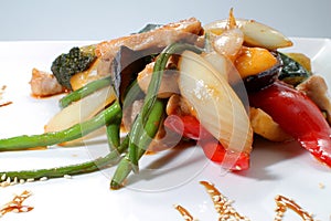 Grilled vegetables with chicken in teriyaki sauce on a white plate