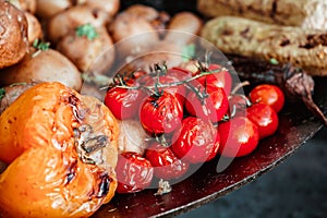 Grilled vegetables, ripe red cherry tomatoes, paprika, potatoes, greens and eggplant in the market, street food 1